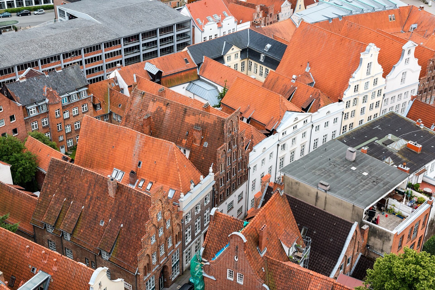 Blick über die roten Ziegeldächer und Giebel einer norddeutschen Altstadt — Bestand, der gewachsen ist und Charakter trägt.